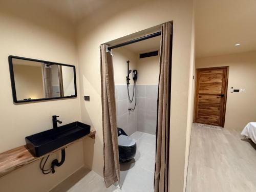 a bathroom with a sink and a mirror at Homey Bamboo Lanta in Ban Ai Dao