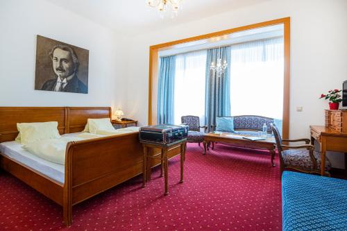 a bedroom with a bed and a large window at Kurhotel & Hotel Mozart in Bad Gastein