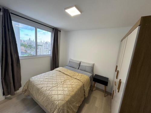 a bedroom with a bed and a large window at bauer in Camboriú