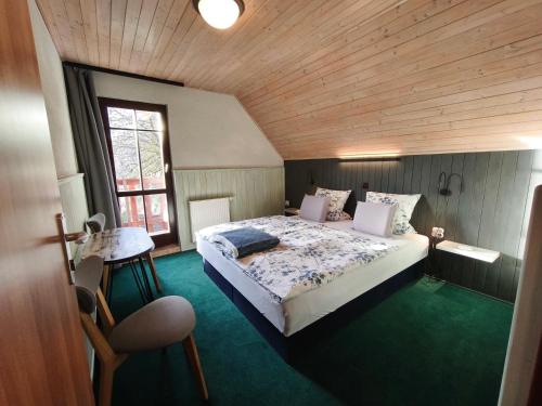 a bedroom with a large bed with a wooden ceiling at Pension DORO in Černý Dŭl