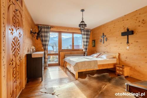 a bedroom with a bed and a large window at Willa Misiek in Zakopane