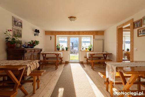 a dining room with tables and chairs and windows at Willa Misiek in Zakopane