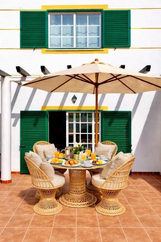 a table with an umbrella on a patio at Casa Da Luz 18 - swimming pool and beach Town house in Luz