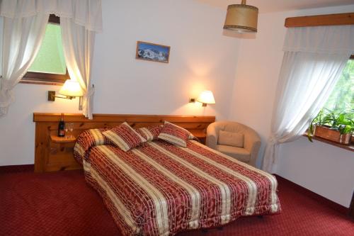 a bedroom with a bed and a chair and a window at Hotel Bosco Verde in Mareson