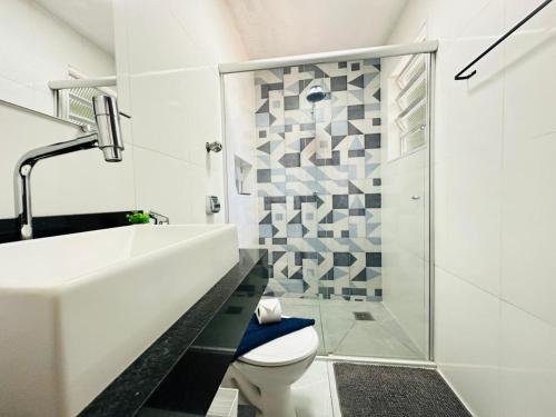 a bathroom with a sink and a toilet and a shower at Ap Aconchego 210 B in Ubatuba