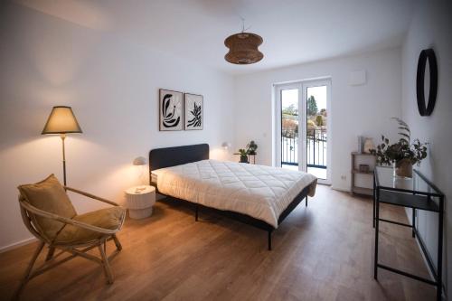 a bedroom with a bed and a chair and a window at Penthouse & Forest Retreat - near city in Bornheim