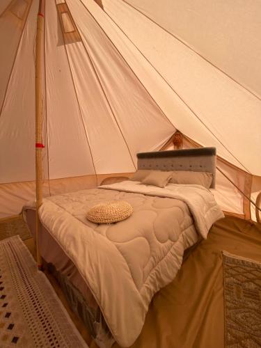 a bed in a tent in a room at Desert Romance Retreat in Muntarib