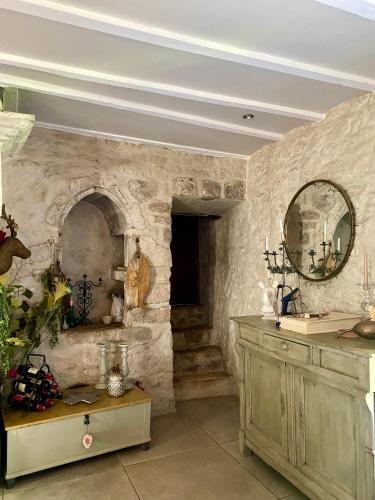 a room with a stone wall with a counter and a mirror at Moulin de Latreille in Calès