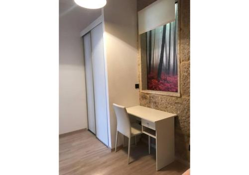 a room with a desk and a painting on the wall at Piso con vistas a 30m playa ALOJAMIENTOS VACAY in Bueu