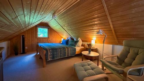 a bedroom with a bed and a chair in a room at Useriner Ferienhaus in Userin
