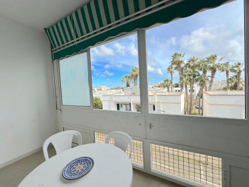 a room with a table and chairs and a large window at Casa Mia - Baia Verde in Baia Verde