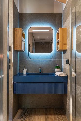 a bathroom with a blue sink and a mirror at Baita Valon La Piciola in Stenico
