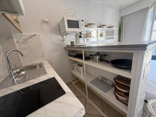 a small kitchen with a sink and a microwave at Studio moderne au cœur de Compiègne in Compiègne