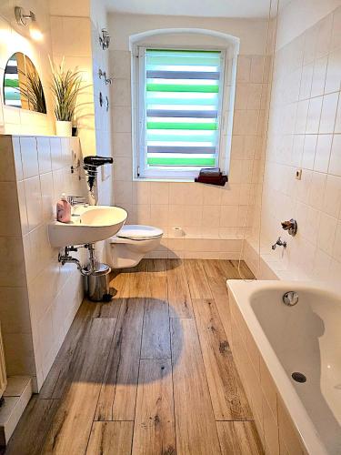 a bathroom with a sink and a toilet and a tub at Cottbuser City Apartment in Cottbus