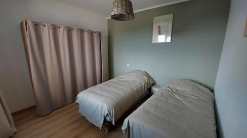 Le gîte des granges في بيدوان: غرفة بها سريران مفردان ونافذة