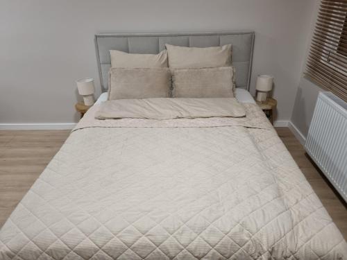 a bedroom with a large bed with a gray headboard at Apartament Sobótka in Sobótka