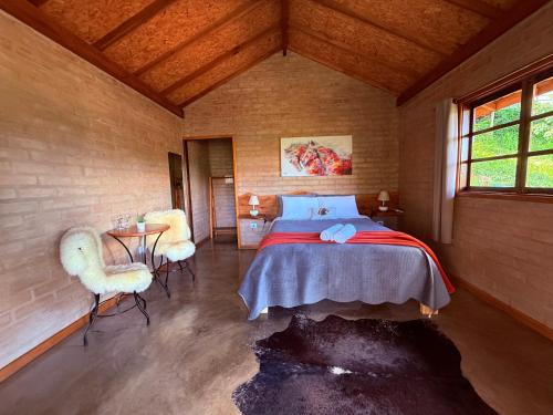 a bedroom with a bed and a table and chairs at Refúgio Horse in Santo Antônio do Pinhal
