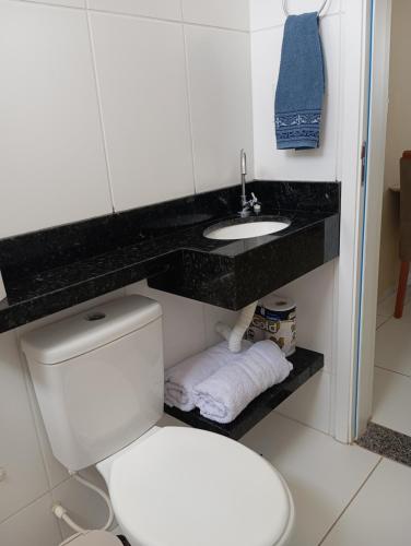 a bathroom with a toilet and a sink at AP Climatizado aconchego com Mercado em frente in Vitória da Conquista