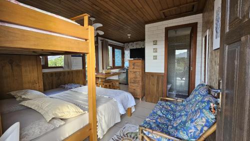 a bedroom with a bunk bed and a kitchen at Casa Kitnet Loft Bidu House in Imbituba