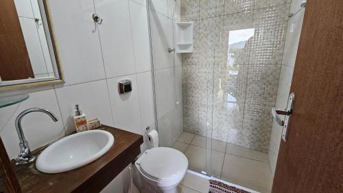 a bathroom with a toilet and a sink and a shower at Casa Kitnet Loft Bidu House in Imbituba