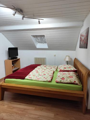 a bedroom with a large bed with red and white sheets at Ferienwohnung Schiekel in Sebnitz