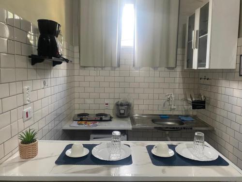 a kitchen counter with two plates and a sink at Studio Home Residence in Jacareí