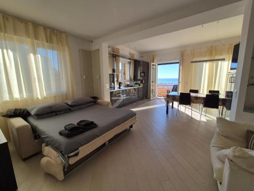 a bedroom with a large bed and a living room at Alloggio Ametista frontemare con posto auto in Lavagna