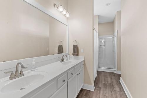 a bathroom with two sinks and a large mirror at Sea La Vie , Walk Everywhere in Rosemary Beach