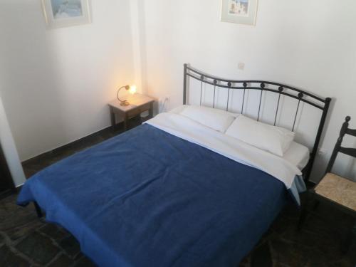 1 dormitorio con 1 cama con manta azul en Villa Ostria, en Kamari