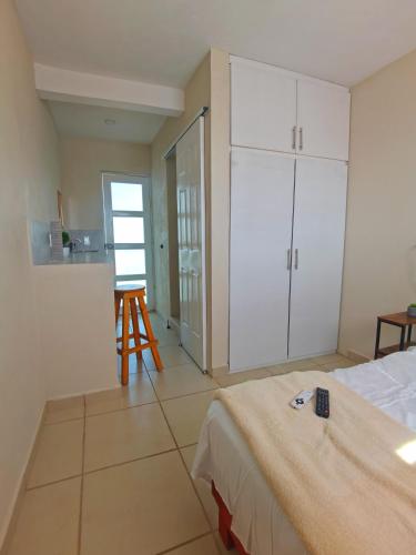 a bedroom with a bed and a kitchen with a table at Villa platino in Pachuca de Soto