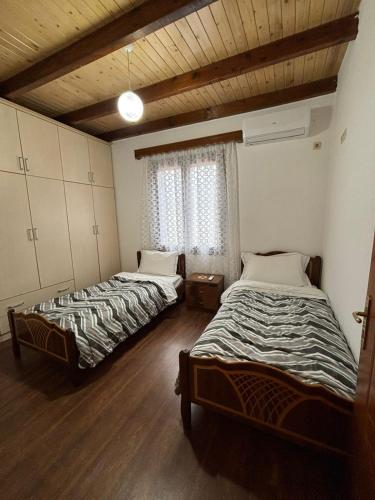 two beds in a room with wooden floors at NoMad House-entire house at your disposal,4 guests in Berat