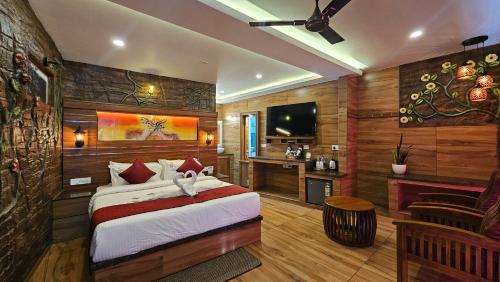 a bedroom with a bed and a desk and a television at S & B Dreams House in Munnar
