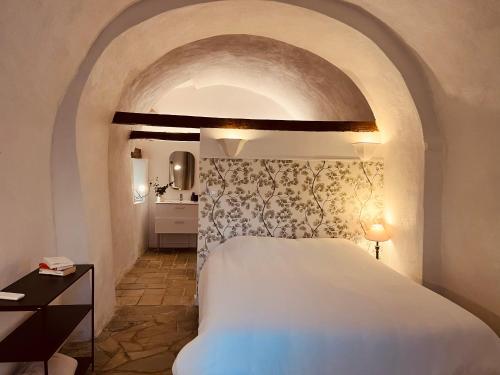a bedroom with a large white bed in a room at La demeure des vignes in Murato