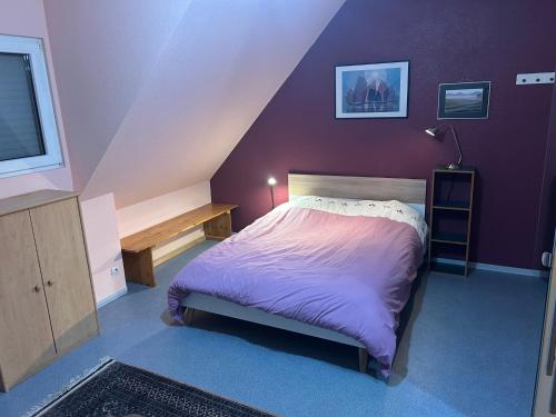 a purple bedroom with a bed and a tv at Chez Corinne et Michel in Saasenheim