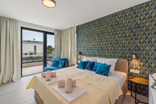 a bedroom with a large bed with blue pillows on it at Villa 7Eight Banjole in Banjole