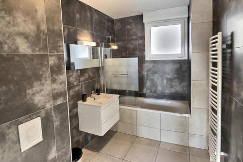 a bathroom with a sink and a tub and a toilet at 50m2 côté Bâle parking inclus in Saint-Louis