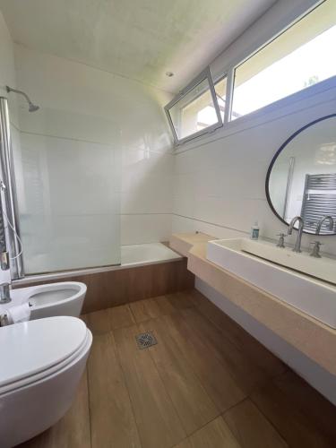 a bathroom with a toilet and a sink and a mirror at Casa Azahares in Yerba Buena