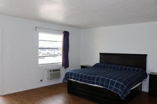 a bedroom with a bed and a window at Dunedin Cove Motel in Dunedin