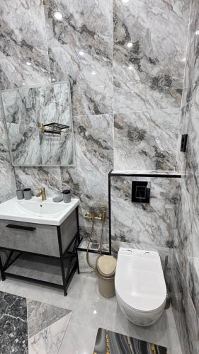 a bathroom with a white toilet and a sink at ЖК Central Park in Aktobe