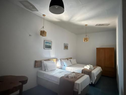 a bedroom with two beds and a table in it at Hotel Pousada 360 in Paracuru