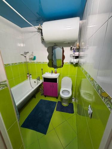 a green bathroom with a toilet and a sink at Gastehaus in Kostyantynivka