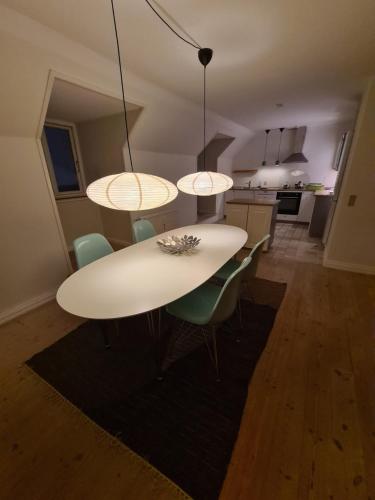 a white table and chairs in a kitchen at Exclusive boende Suite 2 med 4 bäddar i stort sovrum varav 2 bäddar kan stänga om sig in Frederikshavn