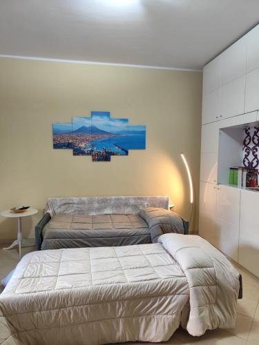 a bedroom with two beds and a flat screen tv at Il Melograno in Terzigno