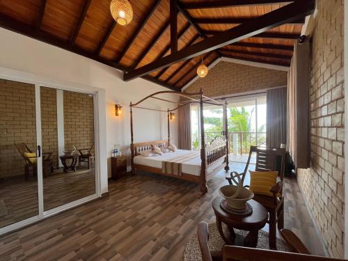 a large room with a bed and a patio at Beach Garden in Weligama