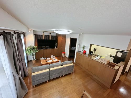 a living room with a couch and a television at Hotel EL 8（宇都宮駅東口） in Utsunomiya