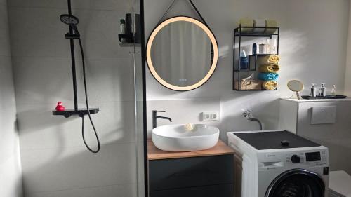 a bathroom with a sink and a mirror at The Garden Residence in Falkenburg