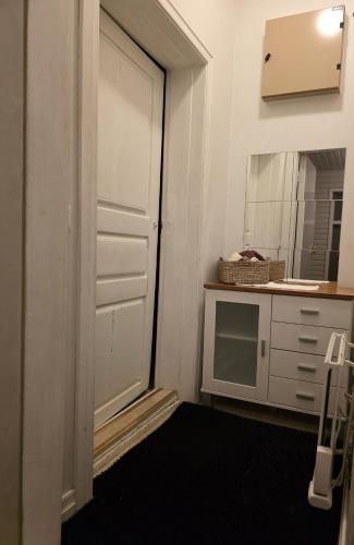 a kitchen with a door and a sink and a microwave at Huoneisto Kuusi in Kokkola