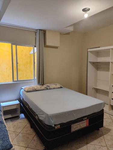 a bedroom with a bed and a window at Casa da Cissa in Matinhos