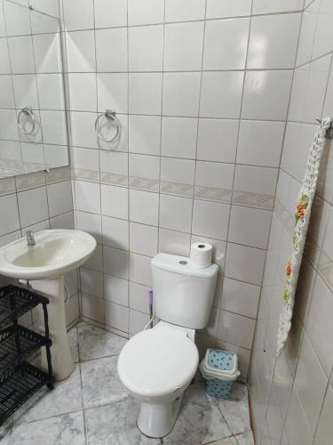 a bathroom with a toilet and a sink at Casa da Cissa in Matinhos
