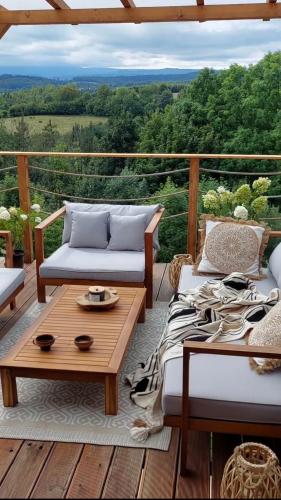 a porch with two couches and a coffee table at Domek DOMiarki in Klecza